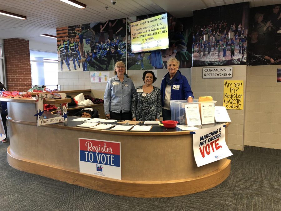 Volunteers from the League of Women Voters  help students register to vote. 