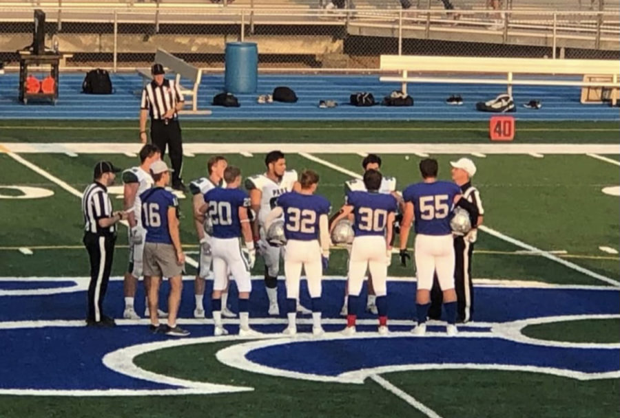 Football Captains walking to center field for coin toss at game vs. Park on Friday September 10th.