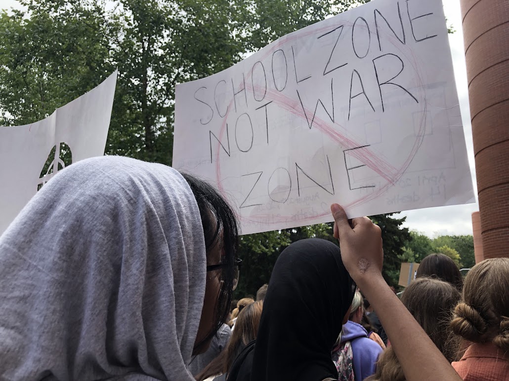 A student at the walkout holds a sign stating, "School zone not war zone". Picture credited to Braeden Hoang.